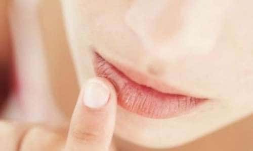 Appliquer un baume à lèvres maison sur les lèvres durant l'hiver